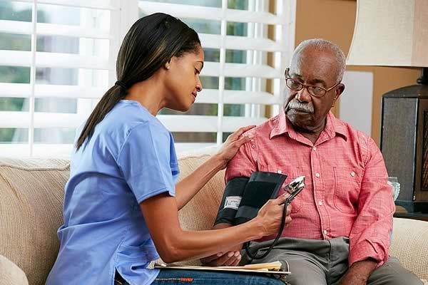 healthcare worker checks man's blood pressure