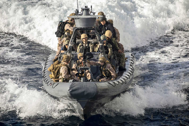 Marines operate a rigid-hull inflatable boat near the USS New York