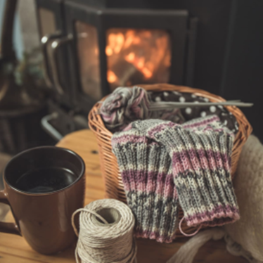 knitting basket, coffee cup in front of the fireplace