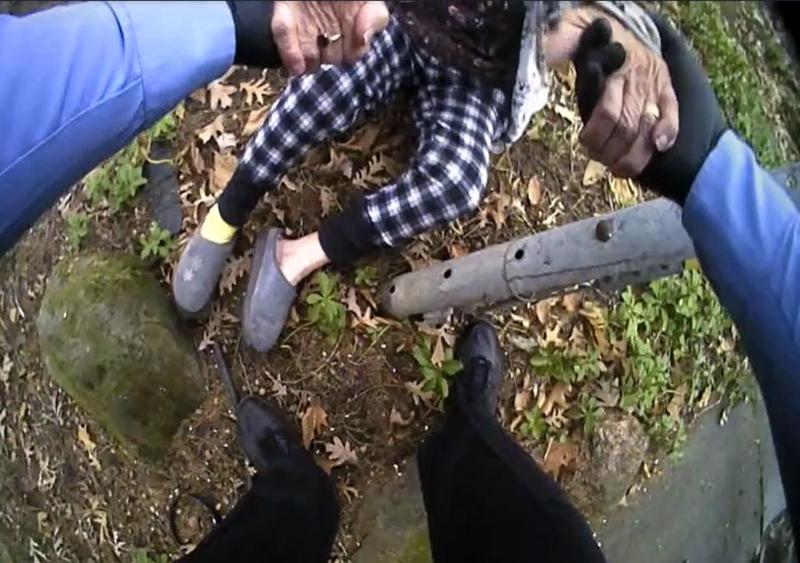 Body camera image of Detective Elyyan helping a fallen woman to her feet.