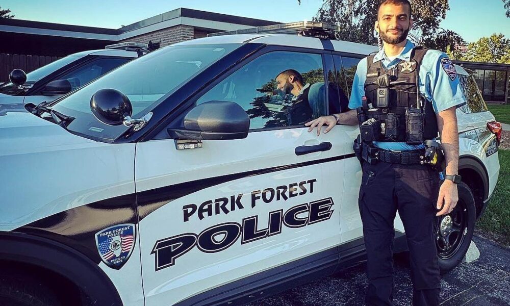 Officer standing next to a squad vehicle.