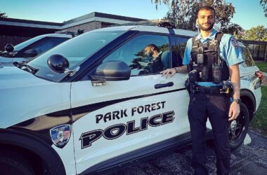 Officer standing next to a squad vehicle.