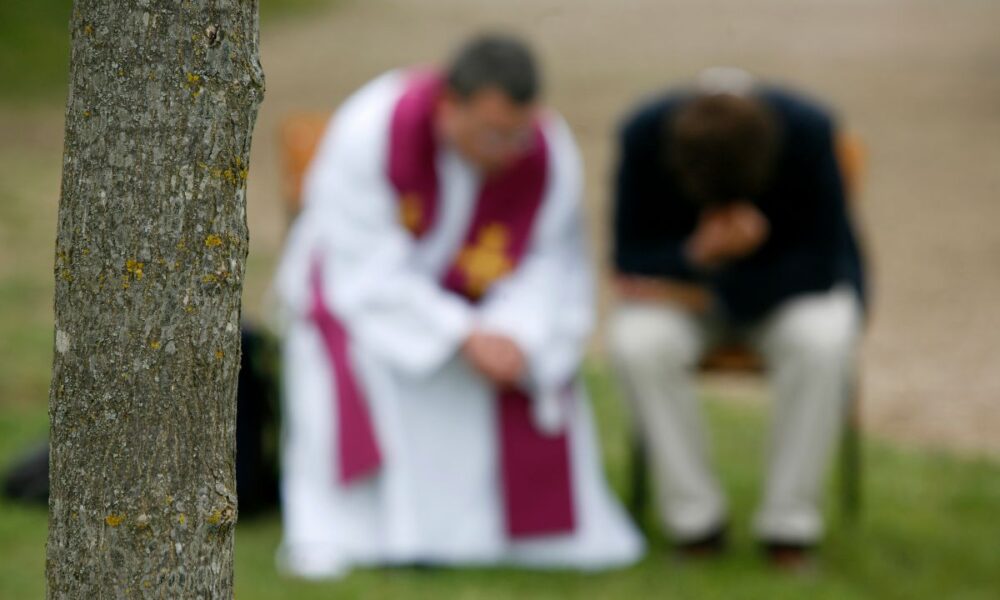 A priest hearing confessions outdoors