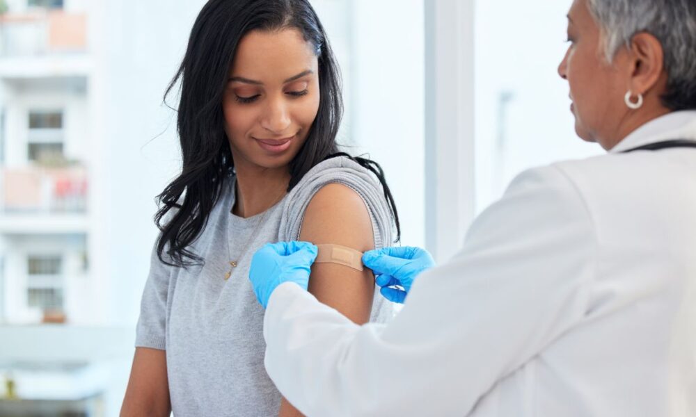 doctor applying bandaid, Community Vaccination Clinic