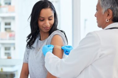 doctor applying bandaid, Community Vaccination Clinic