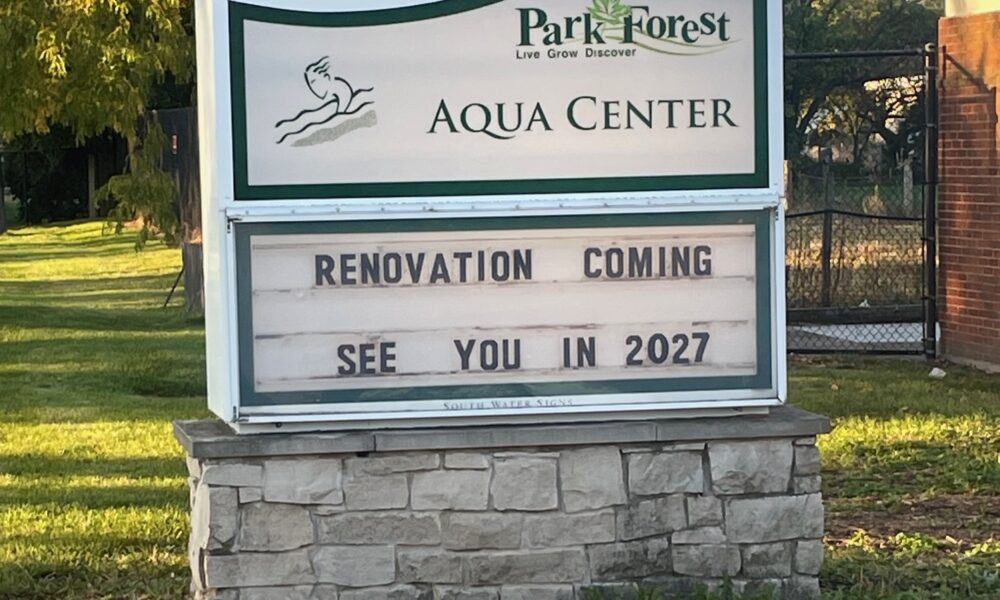 Sign on a stone base in a grassy area