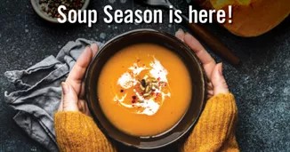 two hands wrapped around a bowl of soup