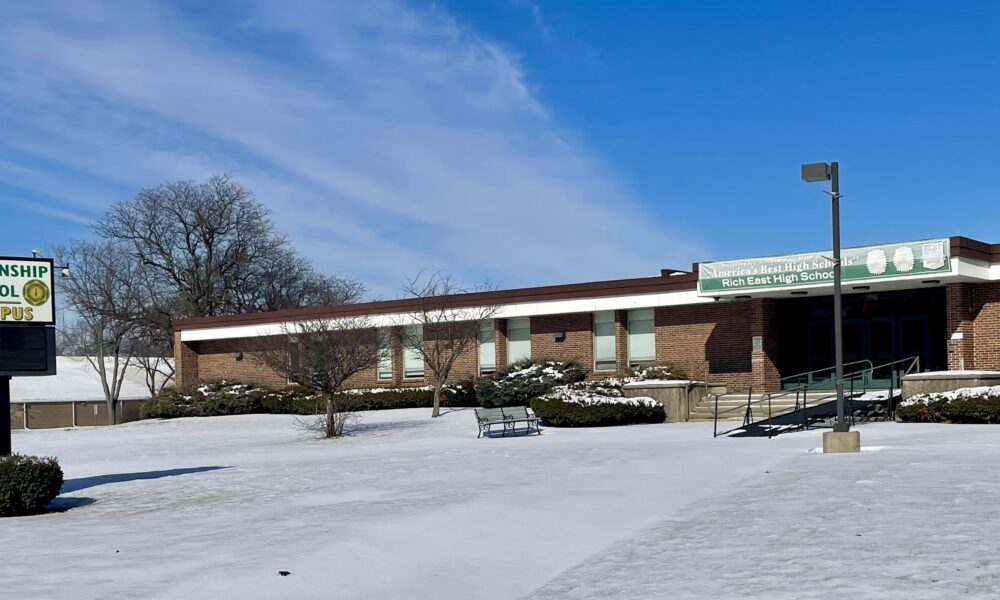 front of a high school building with snow covering the grounds