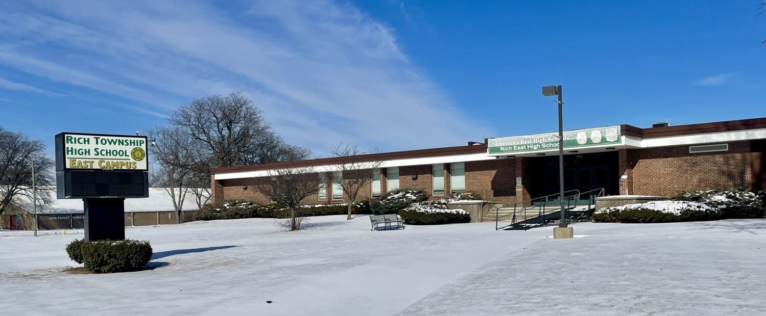 front of a high school building with snow covering the grounds