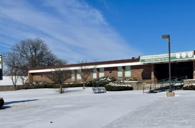 front of a high school building with snow covering the grounds