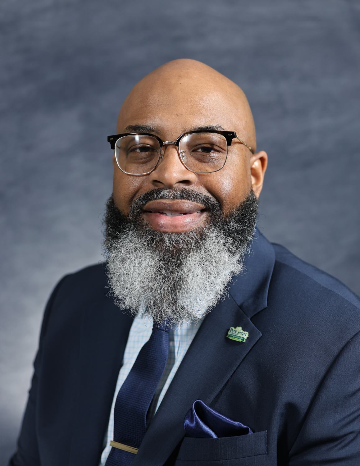 man with a beard and glasses, wearing a suit and tie