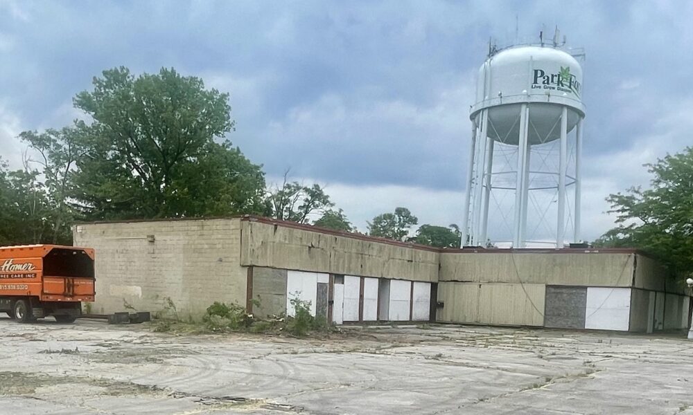 boarded up strip mall with orange truck next to it