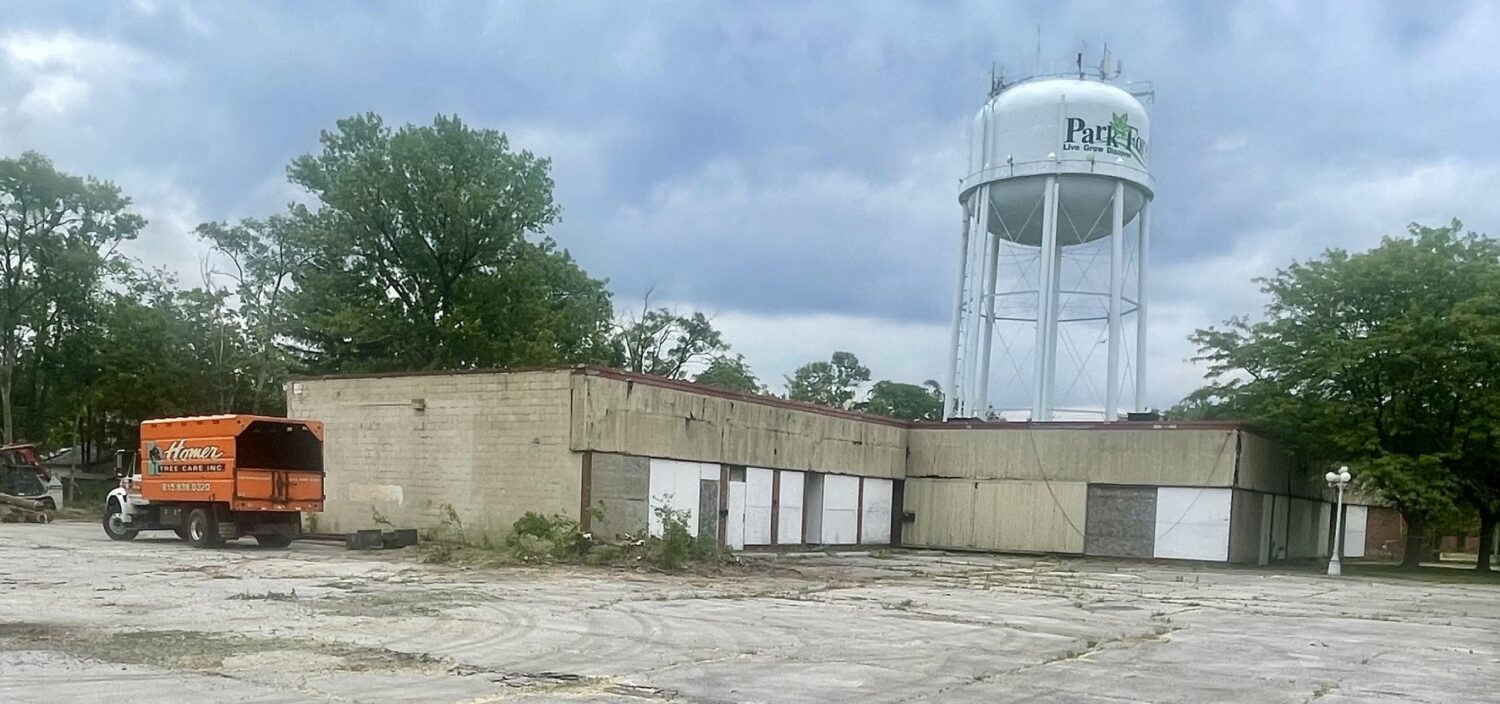 boarded up strip mall with orange truck next to it
