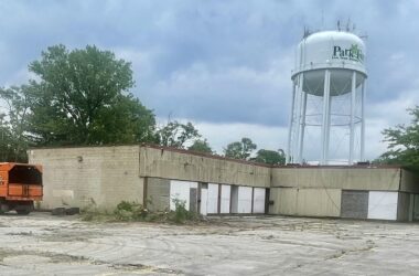 boarded up strip mall with orange truck next to it